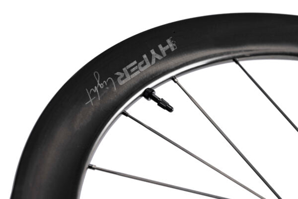 Lún HYPER LIGHT carbon fiber bicycle wheel, close-up of deep-section rim with debossed HYPER branding. Product appearance.