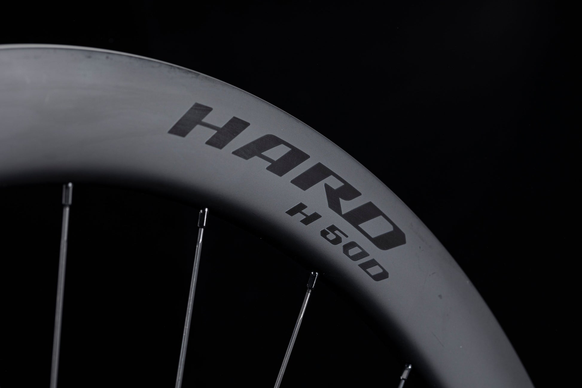 Matte black UNAAS HARD H50D carbon wheelset rim with white decal, 50mm deep.